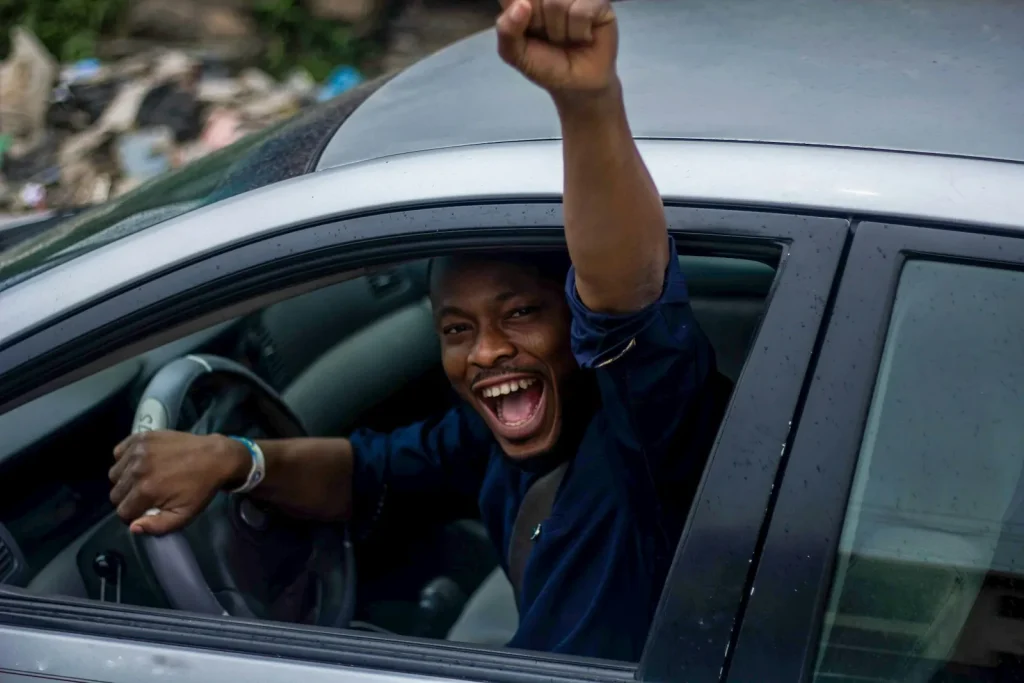 Excited new driver raising a fist out of the car window